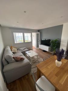 uma sala de estar com um sofá e uma mesa em Apartamento Arousa Mar em Vilanova de Arousa
