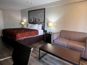 una camera d'albergo con letto e divano di Super 8 by Wyndham Baytown/Mont Belvieu a Eldon