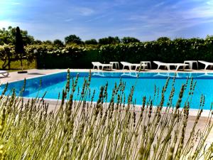 una piscina con mesas y sillas frente a ella en Pansion Villa Margerita, en Poreč