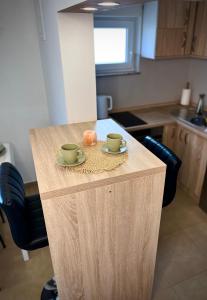 una cocina con una mesa con dos tazas de café y una rosquilla en App Sunny Umag, en Umag