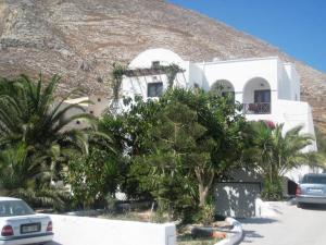 a white building with palm trees in front of it at Vocamvilia Apartments in Kamari