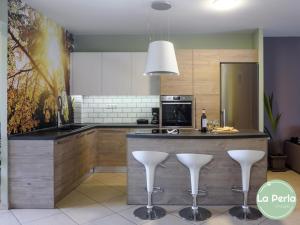 a kitchen with a bar with white stools at VillasDiNafplio - DIVA & PERLA in Nafplio