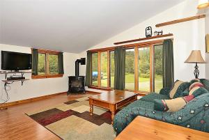 sala de estar con sofá y mesa en Falls Brook Camp, en Stowe