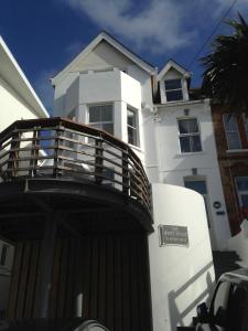 a white house with a wooden balcony in front of it at The White House Hotel in Newquay