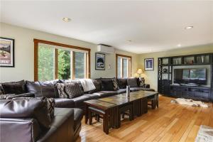 a living room with a leather couch and a table at Mountain Falls in Stowe
