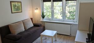 - un salon avec un canapé et une table dans l'établissement Najs Apartamenty z parkingiem, à Sopot