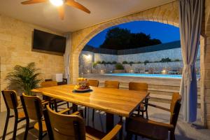 a dining room with a table and a pool at Luxury Villa Petros in Malinska