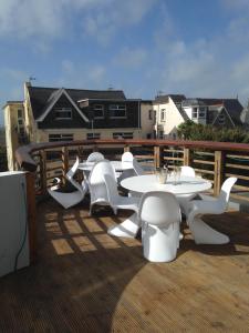 a group of white tables and chairs on a deck at The White House Hotel in Newquay