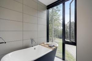 uma banheira na casa de banho com uma grande janela em Sterling Treehouse em Stowe