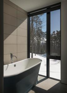 uma banheira na casa de banho com uma janela em Sterling Treehouse em Stowe