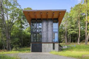 a building in the middle of a forest at Sterling Treehouse in Stowe