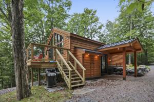 a cabin in the woods with stairs leading up to it at Owls' Nest in Stowe