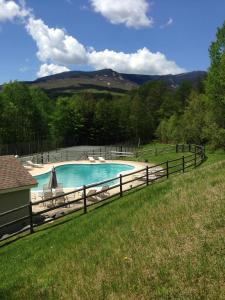 a swimming pool with chairs and a fence at Owls' Nest in Stowe