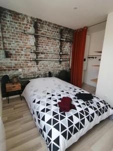 TonneinsにあるJoli 2 pièces Club Houseのベッドとレンガの壁がある寝室