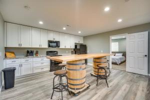 una cucina con armadi bianchi e un bancone in legno con sgabelli di Waterfront Buckeye Lake Vacation Rental with Hot Tub a Hebron