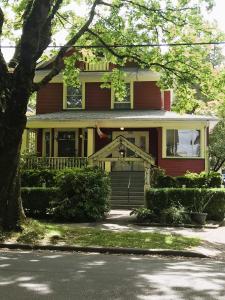 a red house with a tree in front of it at Douglas Guest House in Vancouver
