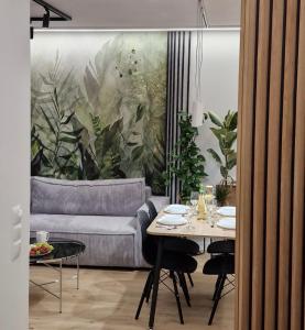 een woonkamer met een tafel en een bank bij Apartament Proszowska 58A, Bochnia, 40 m2 z prywatnym miejscem postojowym in Bochnia