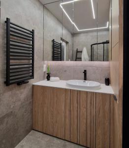 a bathroom with a sink and a mirror at Apartament Proszowska 58A, Bochnia, 40 m2 z prywatnym miejscem postojowym in Bochnia