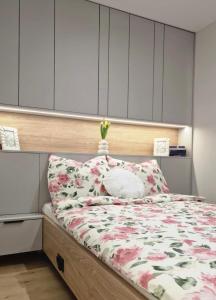 um quarto com uma cama com colcha floral em Apartament Proszowska 58A, Bochnia, 40 m2 z prywatnym miejscem postojowym em Bochnia
