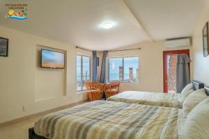 a bedroom with two beds and a large window at Rancho Percebu Beach Studio 4 in Don Pancho