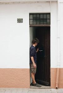 un hombre parado en la puerta de un edificio en Traditional House (renovated) 150m from the sea, en Roses