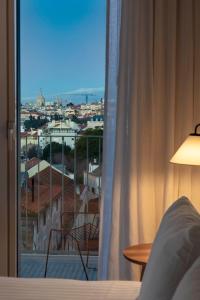 a bedroom with a window with a view of a city at Patio do Tijolo in Lisbon