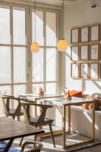 a dining room with tables and chairs and windows at Patio do Tijolo in Lisbon
