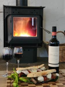 a bottle of wine next to a sandwich and wine glasses at DAYLESFORD Frog Hollow Estate THE BARN - Wanting a different experience - Stay in the Barn - Table Tennis Table - Cinema Projector - Bar - Wood Fireplace - 3 QUEEN BEDS - A fun place for everyone in Daylesford