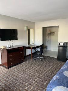 Habitación de hotel con escritorio y TV en New Budget Inn en Eaton
