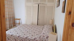 a bedroom with a bed and a window with white shutters at La Casetta in Codevilla - Roburent in Roa Marenca