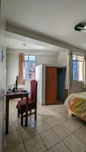 une chambre avec un bureau et un lit et une chambre avec un ordinateur dans l'établissement Hospedaje Arequipa, à Ayacucho