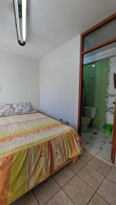 a bedroom with a bed and a bathroom with a toilet at Hospedaje Arequipa in Ayacucho