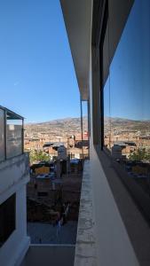 a person sitting on the ledge of a building looking out at the city at Hospedaje Arequipa in Ayacucho