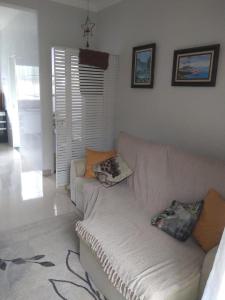 a living room with a white couch with pillows on it at Apartamento Ubatuba in Ubatuba