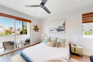 a bedroom with a bed and a large window at Seaside Serenity Retreat Inviting condo in Oceanside with rooftop, hot tub, balcony, and ocean views in Oceanside +41 photos