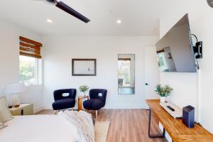 a bedroom with a bed and two chairs and a desk at Seaside Serenity Retreat Inviting condo in Oceanside with rooftop, hot tub, balcony, and ocean views in Oceanside