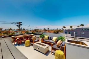 a patio with a table and chairs on a roof at Seaside Serenity Retreat Inviting condo in Oceanside with rooftop, hot tub, balcony, and ocean views in Oceanside