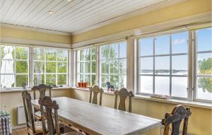 d'une salle à manger avec une table en bois et des fenêtres. dans l'établissement 4 Bedroom Beautiful Home In Eskilstuna, à Sundby