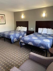 una habitación de hotel con 2 camas y una silla en New Budget Inn en Eaton
