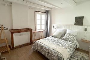 ein weißes Schlafzimmer mit einem Bett und einem Fenster in der Unterkunft AU BOL D'AIR in Saint-Appolinaire