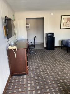 oficina con escritorio, cama y habitación en New Budget Inn en Eaton