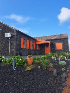 una casa con un jardín delante de ella en Casa Baleia Laranja Ocean-Front, en Cabeço Chão