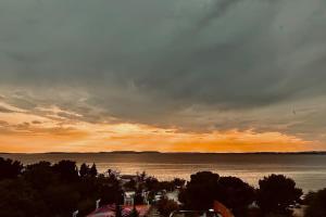 um pôr-do-sol sobre uma grande massa de água em T4 jolie vue avec jaccuzzi em Vitrolles