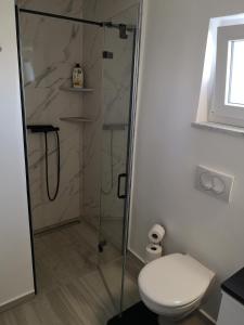 bagno con doccia e servizi igienici. di Apartman The View Krk a Krk