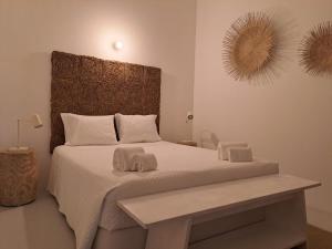 a bedroom with a large bed with two towels on it at Casa Atlântico Carvalhal Comporta, apartamento piscina aquecida in Carvalhal +28 photos