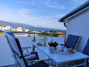 a table with a bowl of fruit on a balcony at Apartman The View Krk in Krk