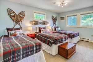 1 Schlafzimmer mit 2 Betten und 2 Fenstern in der Unterkunft Mountain Haus in Stowe