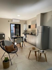 eine Küche mit einem Kühlschrank sowie einem Tisch und Stühlen in der Unterkunft Departamento céntrico BELGRANO in San Salvador de Jujuy