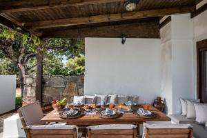 een eetkamer in de openlucht met een houten tafel en stoelen bij Villa Sunrise Majestic Seaview with Private Pool in Chersonissos