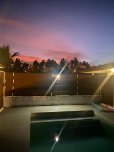 a swimming pool with a sunset in the background at Jorsen House Tahiti 2 : bungalow confortable in Taravao